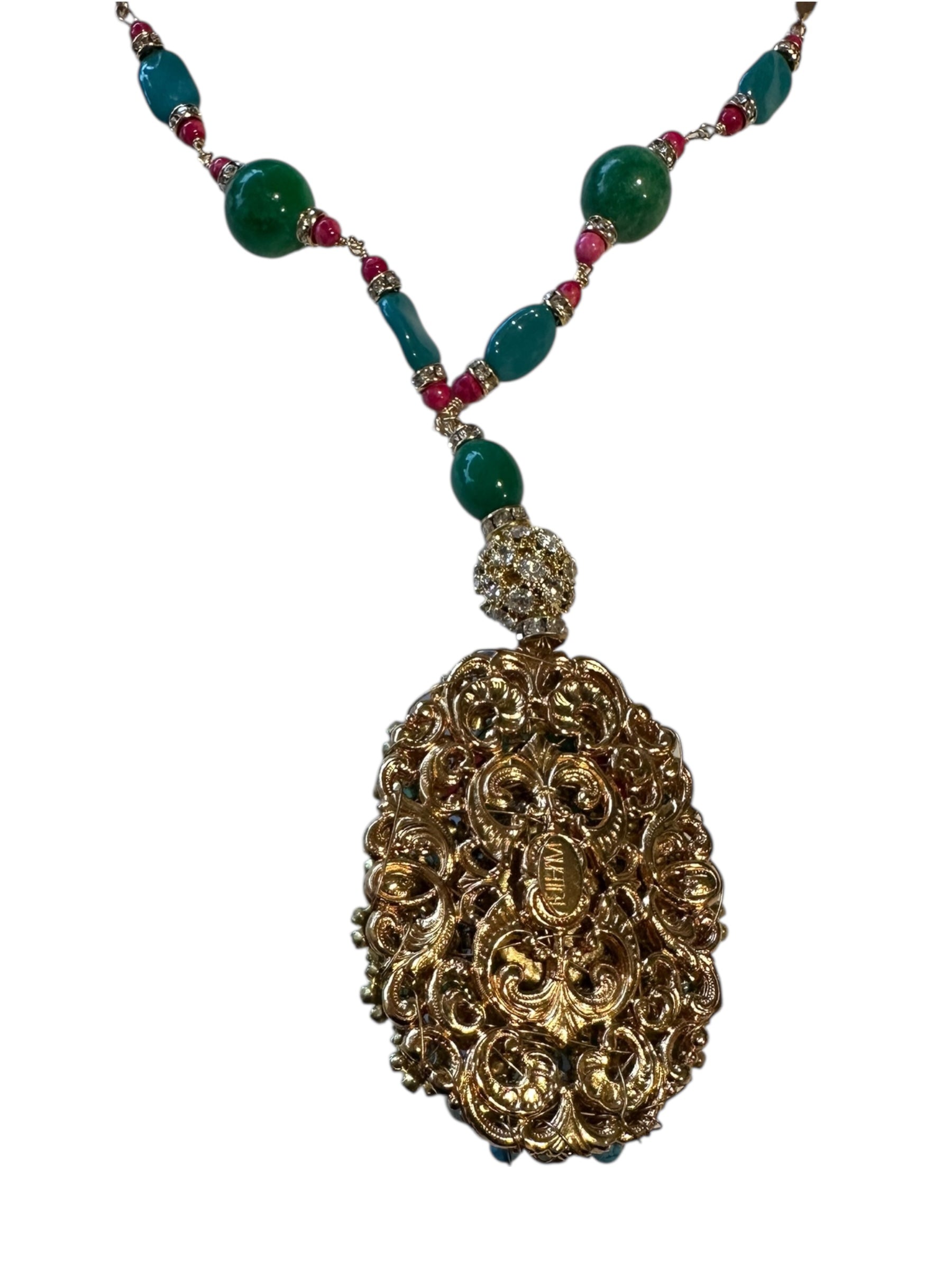 Close-up of the gilt filigree scrollwork back of the pendant on its beaded chain