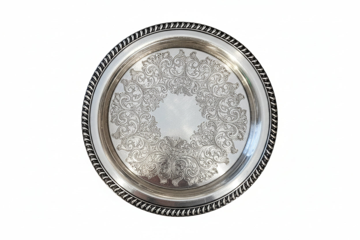 Vintage 12.5 inch silver plate tray with engraved scrollwork center and gadrooned rim, on white