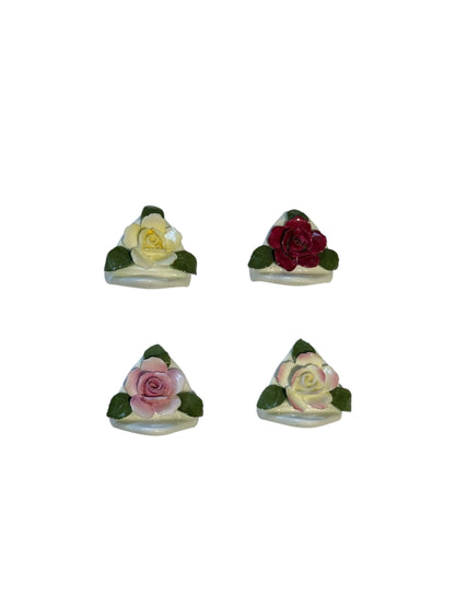 Four porcelain rose place card holders viewed from above showing detailed petal sculpting