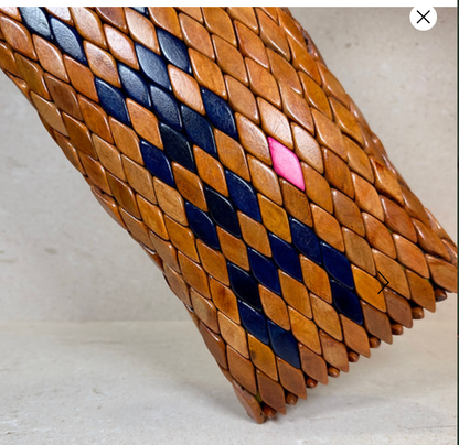 Ma'aM Kind woven wood clutch in saddle tan, close-up of scale-tiled surface with navy and pink accents