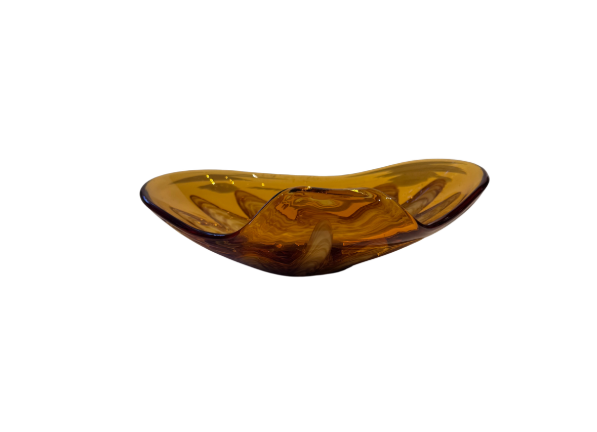 Vintage translucent amber glass dish with an irregular curved rim and a raised cream-and-brown swirled floral starburst design in the center.