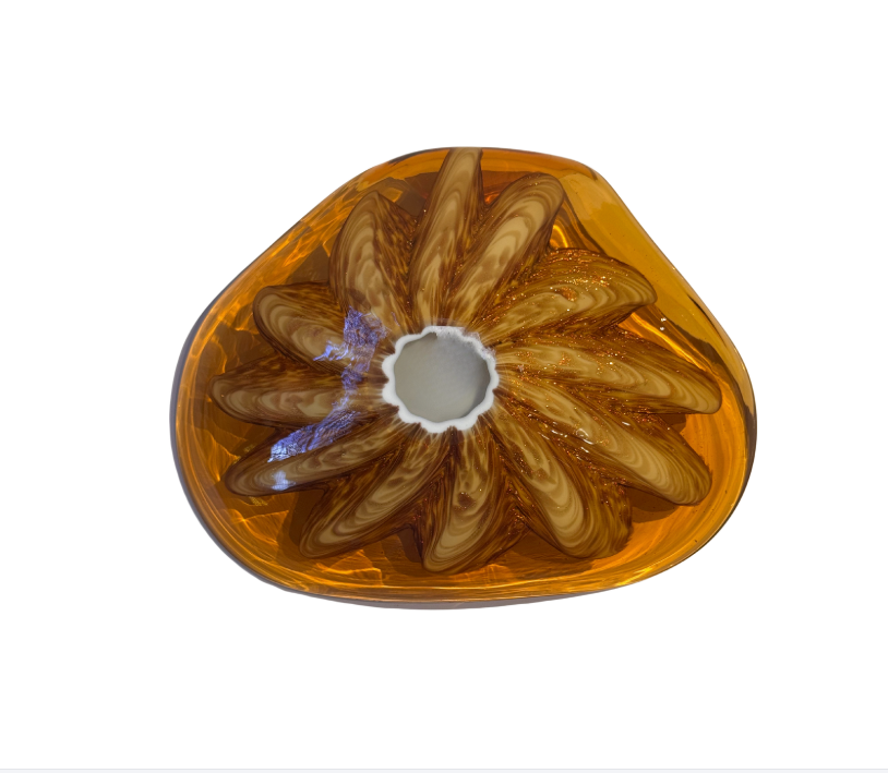 Vintage translucent amber glass dish with an irregular curved rim and a raised cream-and-brown swirled floral starburst design in the center.