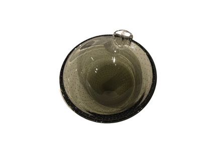 Vintage smoky gray-green glass ashtray with a rounded bowl, evenly spaced controlled bubbles, dark glass rim, and a single clear sculptural cigarette rest.