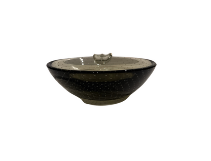 Vintage smoky gray-green glass ashtray with a rounded bowl, evenly spaced controlled bubbles, dark glass rim, and a single clear sculptural cigarette rest.
