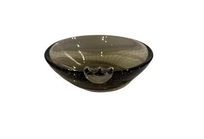 Vintage smoky gray-green glass ashtray with a rounded bowl, evenly spaced controlled bubbles, dark glass rim, and a single clear sculptural cigarette rest.