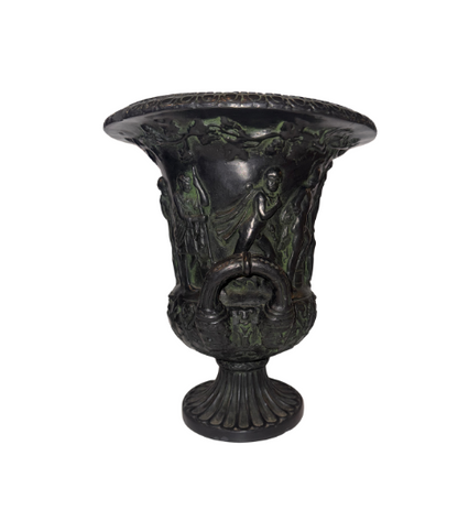 Side View, Black faux-bronze Neoclassical Medici urn with green patina accents, measuring 11 inches tall and 9 inches in diameter. The Campana-shaped vessel features a wide flared rim with egg-and-dart detailing, raised Greco-Roman figures in various poses, grapevine and leaf borders, and two reeded loop handles with bearded mask decorations. An intricate floral and acanthus leaf design surrounds the lower bowl, which rests on a fluted circular pedestal base.
