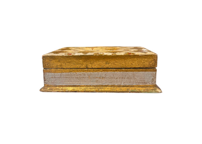 Side Front View: Low-angle view of a rectangular Italian Florentine box with a gilded lid, distressed ivory sides, and a projecting gold-painted base.