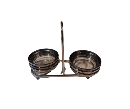 Angled view of six vintage round glass coasters with platinum-tone fade rims, stacked in a two-sided metal carrying caddy.