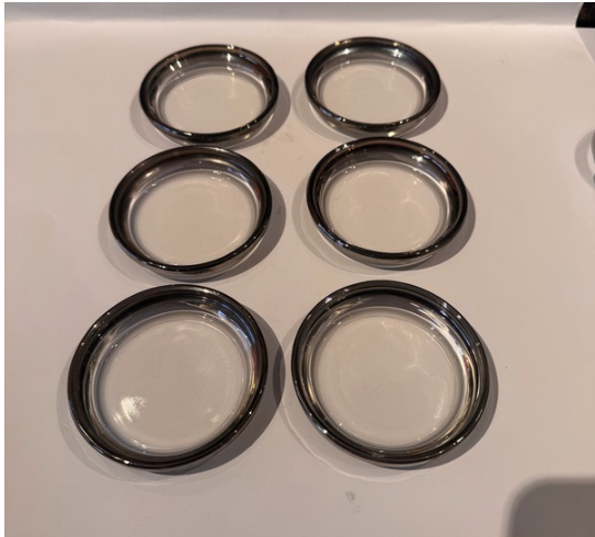  Six vintage clear glass coasters with reflective silver fade rims arranged individually in two columns of three.
