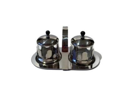 Vintage Michael Graves cream and sugar set featuring two glass containers in chrome holders with black lids on a matching oval caddy.