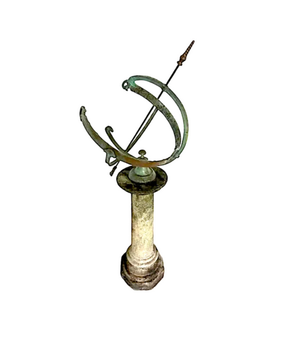Antique bronze armillary sundial with verdigris rings and an arrow gnomon atop a pale stone column pedestal