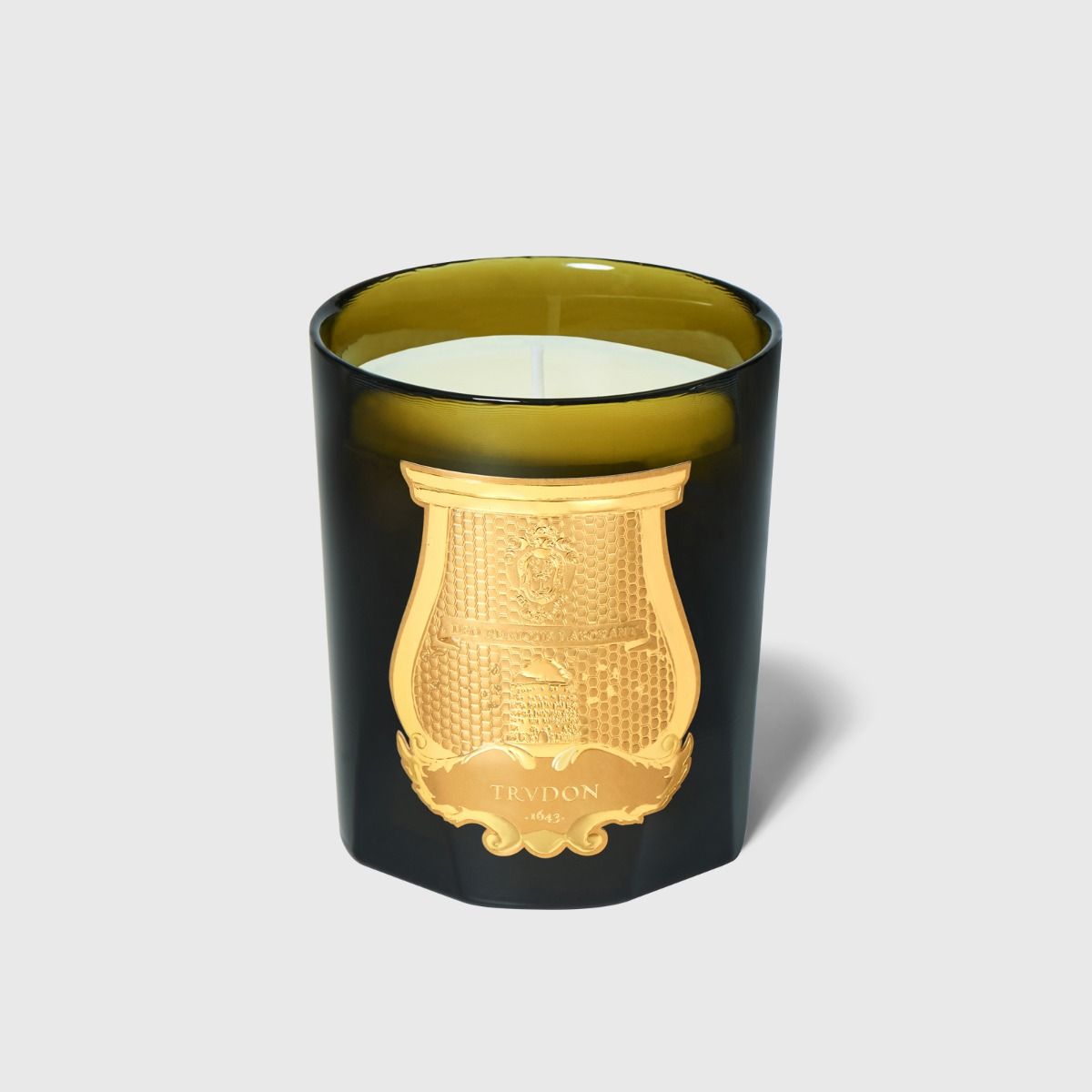 Trudon Josephine candle in dark green glass jar with embossed gold crest emblem, front view