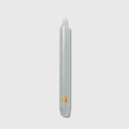 Single Trudon Madeleine grey taper candle with gold Trudon crest seal near the base