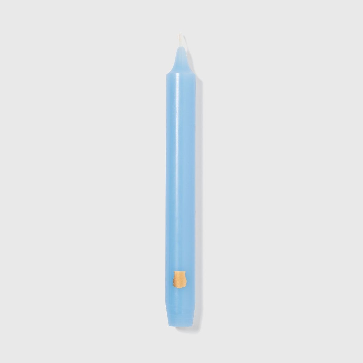 Single Trudon Madeleine skye blue taper candle with gold Trudon crest seal near the base