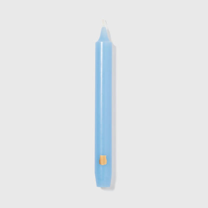 Single Trudon Madeleine skye blue taper candle with gold Trudon crest seal near the base
