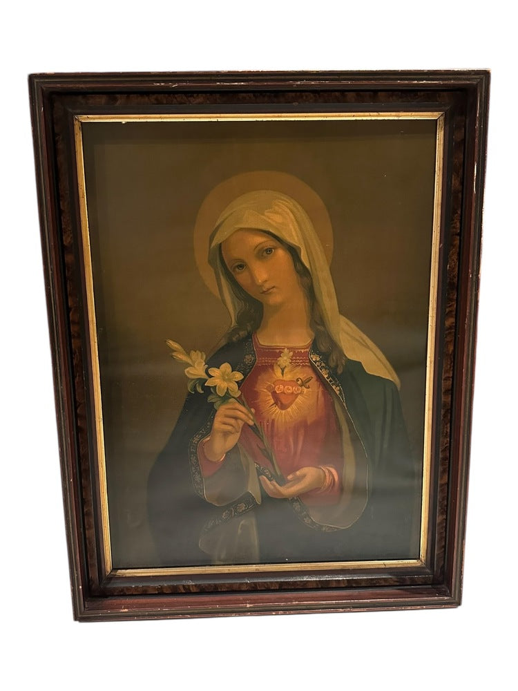 Framed antique oil painting of the Immaculate Heart of Mary with a lily, dark wood frame, slightly angled view