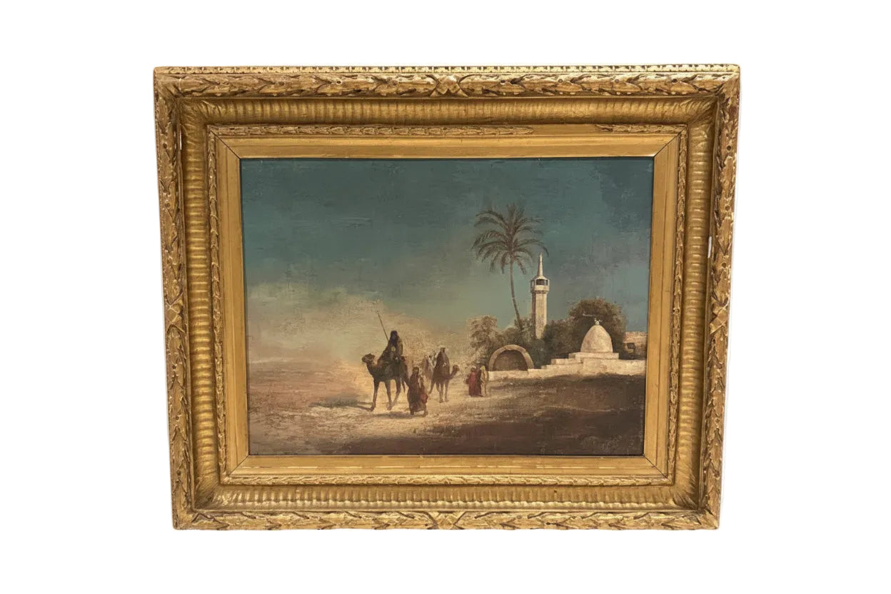 Antique framed oil on canvas Orientalist scene of robed figures and camels near a desert mosque with palm trees, in an ornate gilt frame