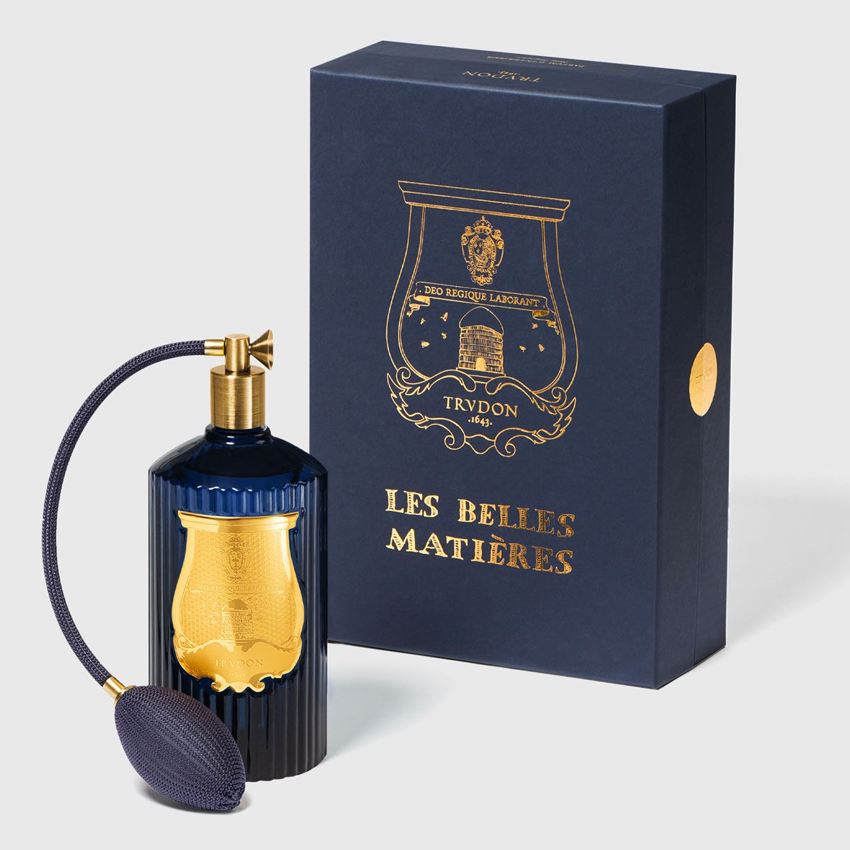 Trudon Reggio room spray bottle beside its navy and gold Les Belles Matières gift box